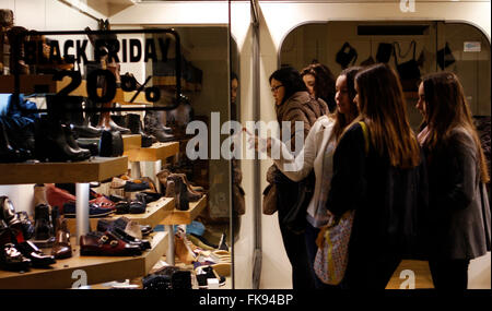 Le ragazze alla ricerca di scarpe in un negozio durante il Venerdì nero. In una giornata aperta e molto affollato. Foto Stock