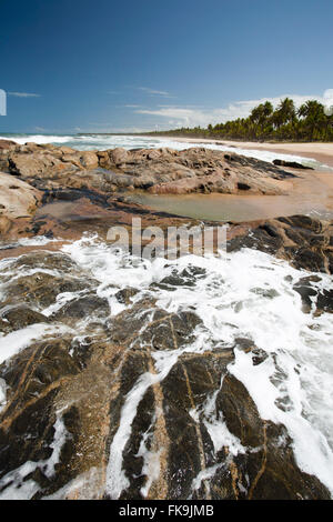 Onde che si infrangono sulle rocce in Imbassai beach - Costa nord Foto Stock