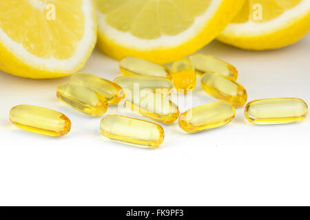 La vitamina c pillole e le fette di limone su sfondo bianco Foto Stock
