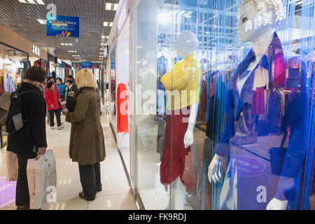Ricerca di acquirenti per i capi di abbigliamento in un centro commerciale a Pechino, Cina Foto Stock