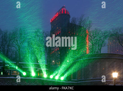 Faretti verde illuminando la caduta di neve con il Fallsview Casino in background. Niagara Falls, Ontario, Canada. Foto Stock