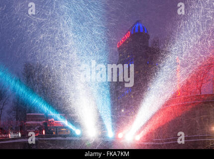 Faretti colorati illuminando la caduta di neve con il Fallsview Casino in background. Niagara Falls, Ontario, Canada. Foto Stock