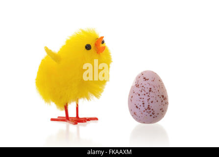 Unico pulcino di pasqua con un uovo di cioccolato, isolato Foto Stock