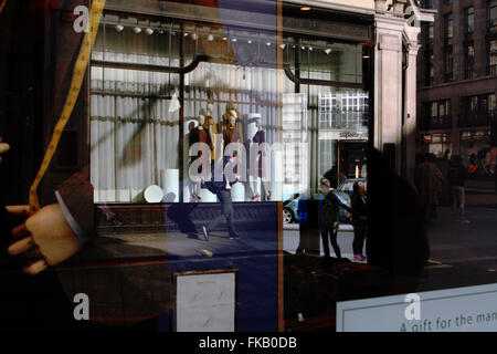 Riflessioni nella finestra di visualizzazione di Austin Reed in Regent Street, Londra, Inghilterra. Foto Stock