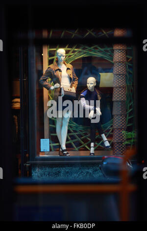 Un store window display in Regent Street, Londra, Inghilterra, visto dalla strada attraverso le finestre di un rosso London bus Foto Stock