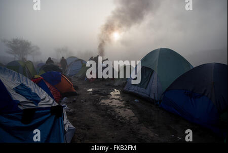 Idomeni, Grecia. 08 Mar, 2016. I rifugiati asciugare i loro abiti dopo forti piogge nel campo profughi al confine Greek-Macedonian vicino Idomeni, Grecia, 08 marzo 2016. Solo pochi rifugiati dalla Siria e Iraq sono ammessi a croce in Macedonia ogni giorno. Foto: KAY NIETFELD/dpa/Alamy Live News Foto Stock