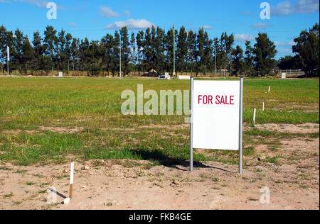 Un'immagine del terreno vacante con una vendita per firmare Foto Stock