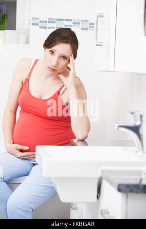 Donna incinta la sofferenza con la malattia di mattina nella Stanza da Bagno Foto Stock