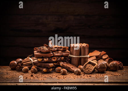 Still Life per il rotto della barra di cioccolato e spezie sul tavolo di legno Foto Stock