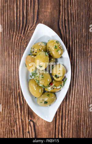 Green Olive in salamoia (close-up shot) con aglio ed erbe fresche Foto Stock