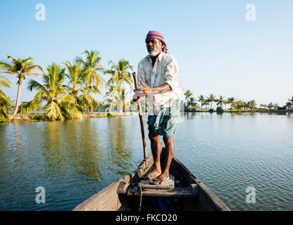 Anthony barcaiolo guida del vaso attraverso il Kerala backwaters vicino a North Paravoor, Kerala, India Foto Stock