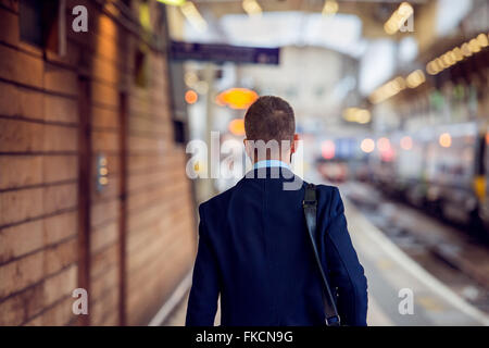 Imprenditore nel soddisfare passeggiate all'staition, vista posteriore Foto Stock