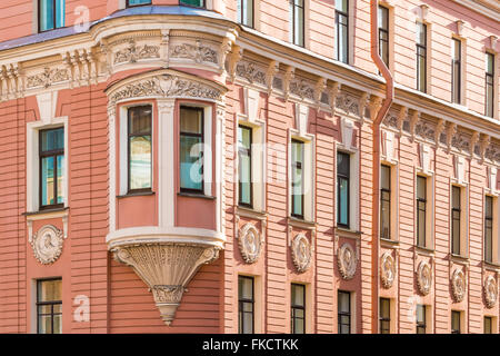 Molte finestre in fila e baia finestra su un angolo della facciata di urban apartment building angolo visuale, San Pietroburgo, Russia Foto Stock