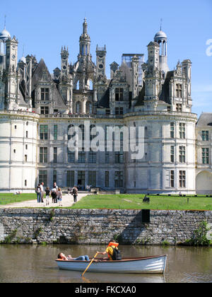 Una coppia in un legno barca a remi sul fossato di fronte al Château de Chambord. Foto Stock