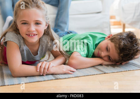 Un ragazzo e una ragazza (6-7, 8-9) giacente sul pavimento Foto Stock