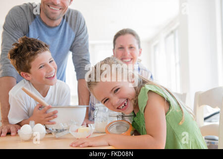 Famiglia con due bambini (6-7, 8-9) preparare il cibo, ridendo Foto Stock