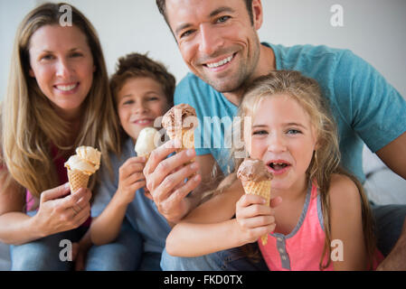 Famiglia con due bambini (6-7, 8-9) azienda coni gelato Foto Stock