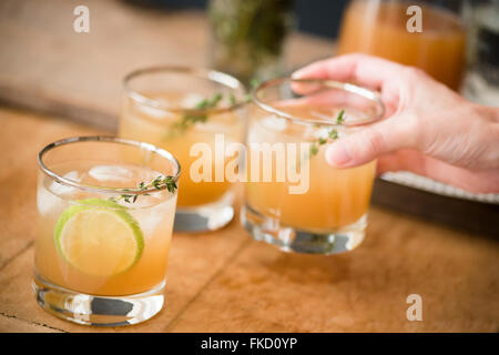 Donna di mano azienda bicchiere con cocktail Foto Stock