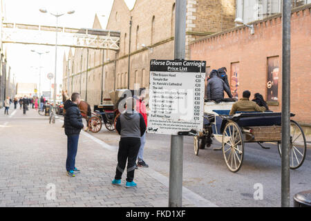 Carrozze trainate da cavalli di prelevare i turisti al di fuori della Guinness Storehouse, Dublino, Irlanda Foto Stock