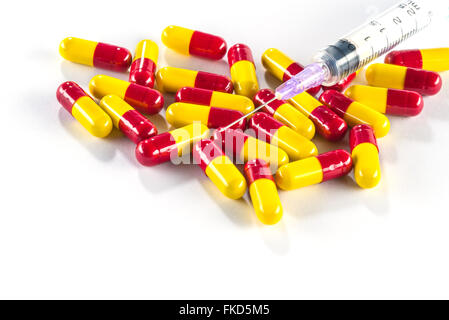 Giallo con capsule di colore rosso e la siringa, farmaco cura close up Foto Stock