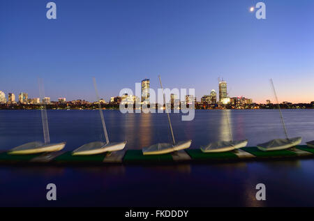 Barche a vela in fila sul molo, cityscape in background Foto Stock