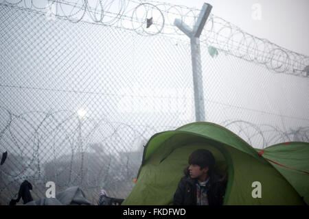 Idomeni, Grecia. 8 Marzo, 2016. Un bambino si sveglia nella sua tenda situata dietro il filo spinato a sunrise nel camp di Idomeni, il confine tra la Grecia e la Macedonia. I migranti nella nebbia a camp di Idomeni in Grecia in attesa di andare oltre il punto di arresto del greco-confine macedone, sulla strada per il camp di Gevgelija in Macedonia. Condizioni di estrema difficoltà al Idomeni's camp dove la popolazione ha superato le 10.000 unità. Credito: PACIFIC PRESS/Alamy Live News Foto Stock