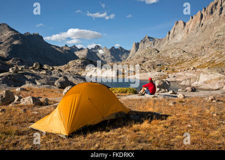 WY01223-00...WYOMING - escursionista rilassante in un campeggio nei pressi di un piccolo lago Titcomb nel bacino del fiume del vento gamma. Foto Stock