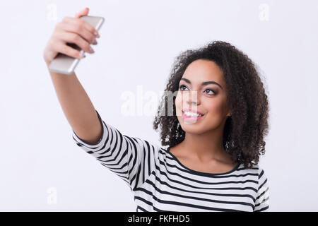 Piacevole mulatto donna fare selfies Foto Stock