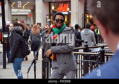 Londra, UK,Marzo 2016,Dee Peacemaker busks a Oxford Circus.Dee pacificatore l Africa è un Edutainment reggae artist dalla Nigeria base UK.Egli scrive canta Politico Sociale Africa ingiustizia. Foto Stock