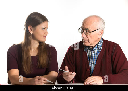 Giovane donna senior aiuta l uomo a riempire di documenti cartacei Foto Stock