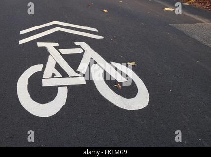 Segno rappresentativo di una bicicletta dipinta di bianco sull'asfalto stradale per indicare una pista ciclabile Foto Stock