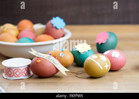 Uovo di Pasqua nastri, sfinestrature, pietre e nastro di designer per la colorazione e la decorazione per la vacanza Foto Stock