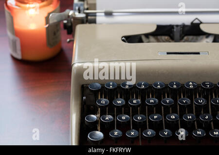 Vintage nastri inchiostratori per macchine da scrivere e la carta su un tavolo sotto lume di candela pronto per l'autore di scrivere una storia. Foto Stock