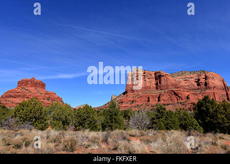 Il red rock formazioni di Sedona in Arizona, dotate di Bell Rock sulla sinistra e il getto di vapore trail nel cielo. Foto Stock