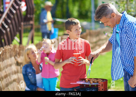 La famiglia felice avente picnic nel parco in una giornata di sole Foto Stock