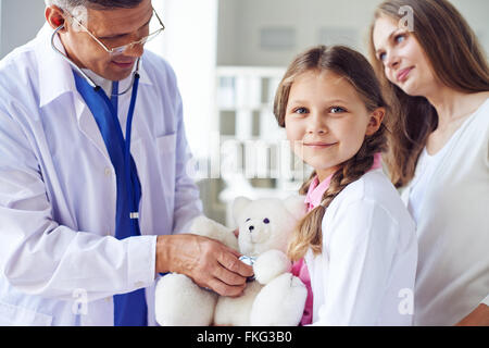 Bambina con Teddy bear visita medico Foto Stock