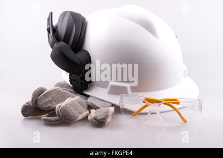 Elmetto e le cuffie di protezione e guanti protettivi e occhiali di sicurezza su sfondo bianco Foto Stock
