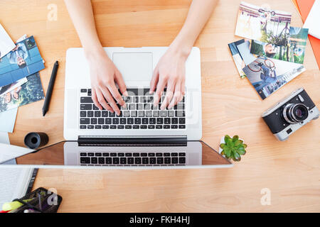 Vista superiore del desktop del giovane donna fotografo lavora con il computer portatile Foto Stock