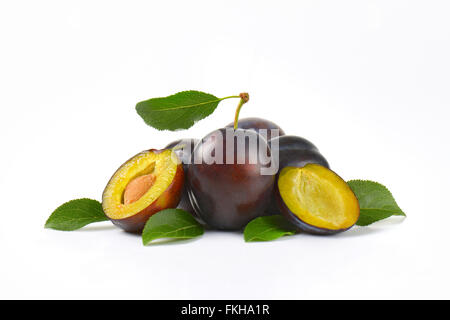 Susine mature con foglie su sfondo bianco Foto Stock