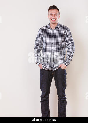 Ritratto di bello di moda uomo in plaid shirt. Giovane ragazzo in posa di studio. Moda casual. Foto Stock