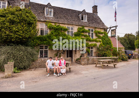 Una famiglia al di fuori del The Swan Inn at Swinbrook vicino a Burford , Oxfordshire , Inghilterra , Inghilterra , Regno Unito Foto Stock