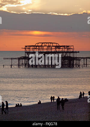 Il sole tramonta sulle rovine del Molo Ovest di Brighton Foto Stock