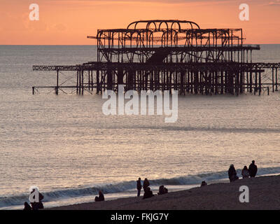 Il sole tramonta sulle rovine del Molo Ovest di Brighton Foto Stock