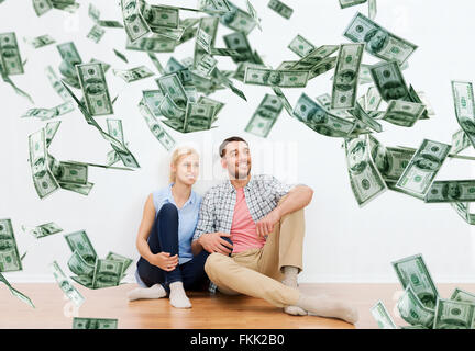 Coppia felice a casa nel corso del dollaro di caduta di denaro Foto Stock