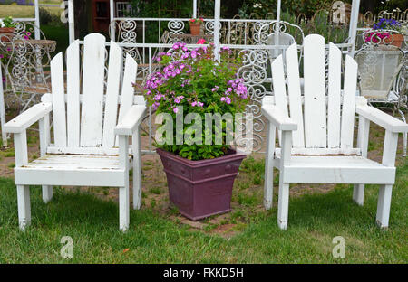 Due antiche in legno bianco sedie da giardino sul patio estivo Foto Stock