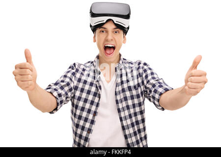 Uomo gioioso dando due pollici in su dopo l'utilizzo di un auricolare VR isolati su sfondo bianco Foto Stock
