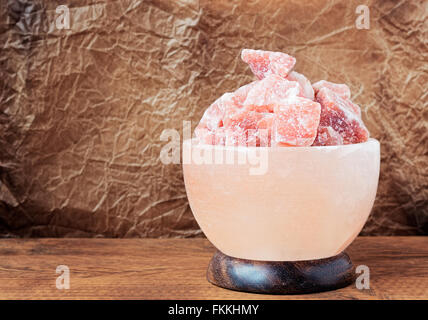 Spento Himalayan sale rosa lampada scolpito come una ciotola su una tavola di legno. Foto Stock