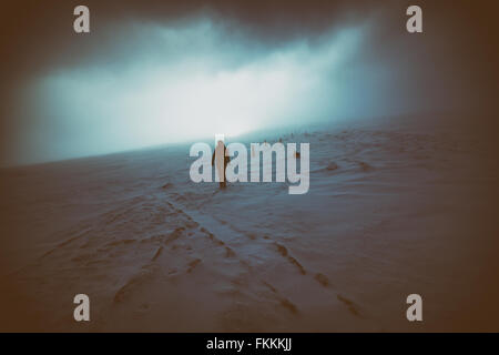 Un escursionista e il loro cane avvicinarsi al vertice di Cairn Gorm come il sole combatte attraverso il cloud, Highlands scozzesi, UK. Aggiunto gr Foto Stock
