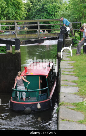 Narrowboat uscendo cancelli di blocco sul Rochdale Canal, Hebden Bridge, Calder Valley, West Yorkshire, Inghilterra Foto Stock
