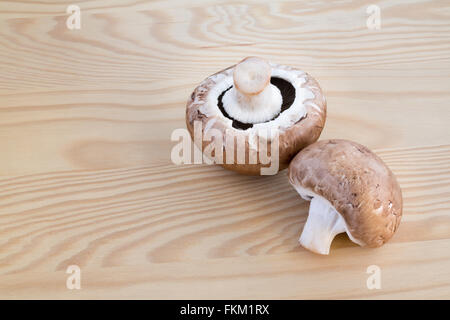 Due funghi castagne su di un tagliere di legno Foto Stock